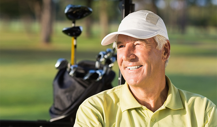 Male golfer looking off smiling.