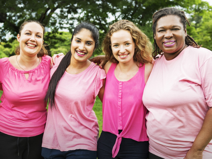 Group of women in pink smiling.