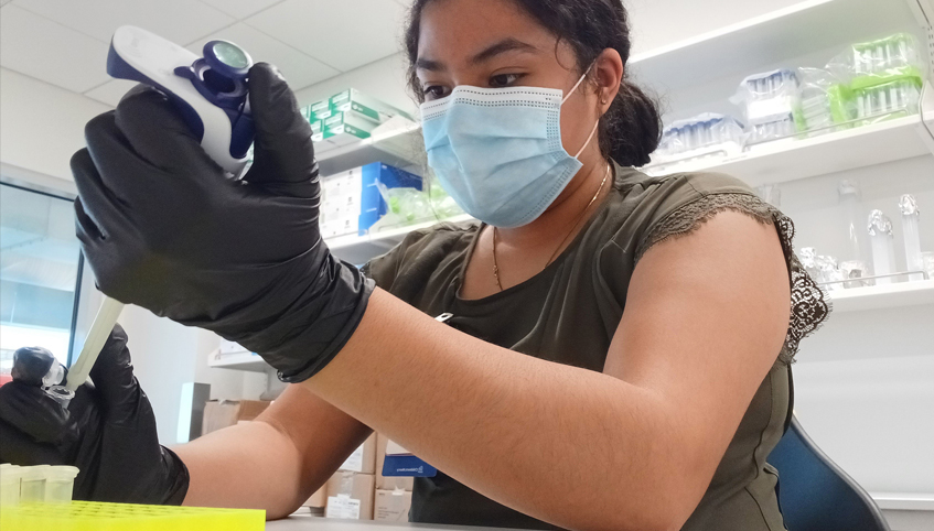 Woman in mask working in a lab