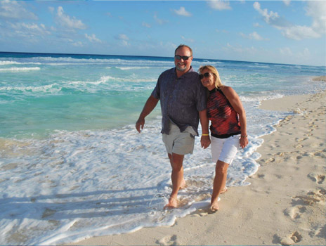 Bill Coppinger walking on beach with wife