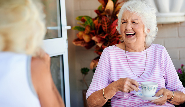 Happy woman drinking tea after her stomach cancer treatment at KU Cancer Center.