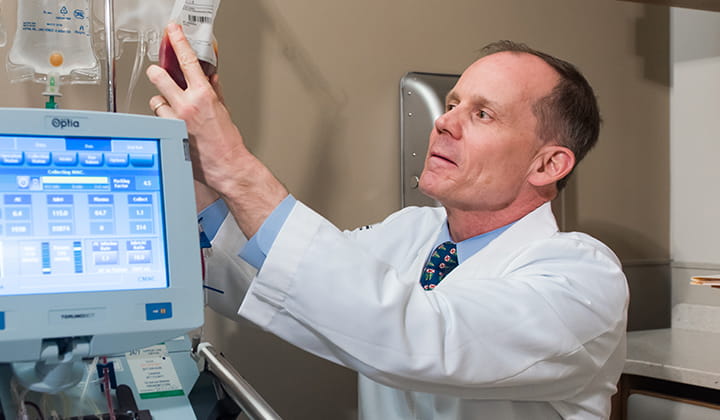 Joseph McGuirk, DO, Division Director, Hematologic Malignancies and Cellular Therapeutics, checks a hanging bag of fluids.