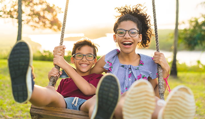 Siblings swinging.