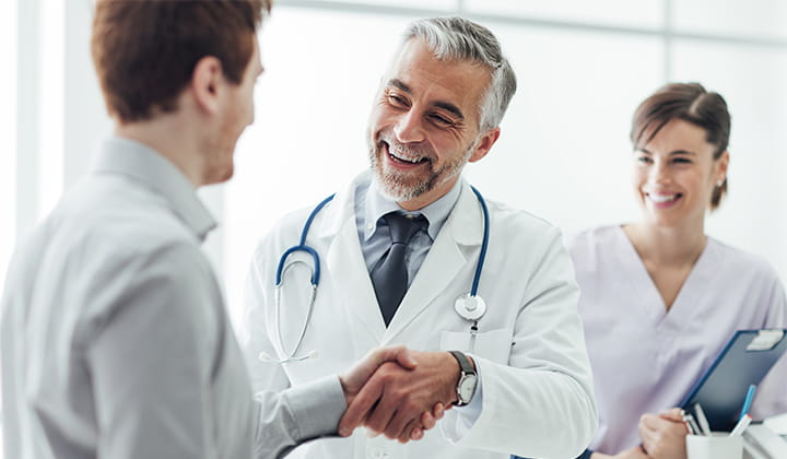 Doctor shaking man's hand.