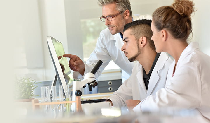 Three doctors looking at computer.