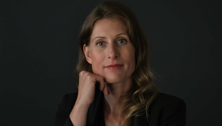 Dr. Brown wears black while sitting in front of a black background