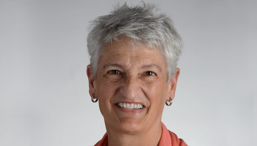 Woman with short, grey hair smiling.
