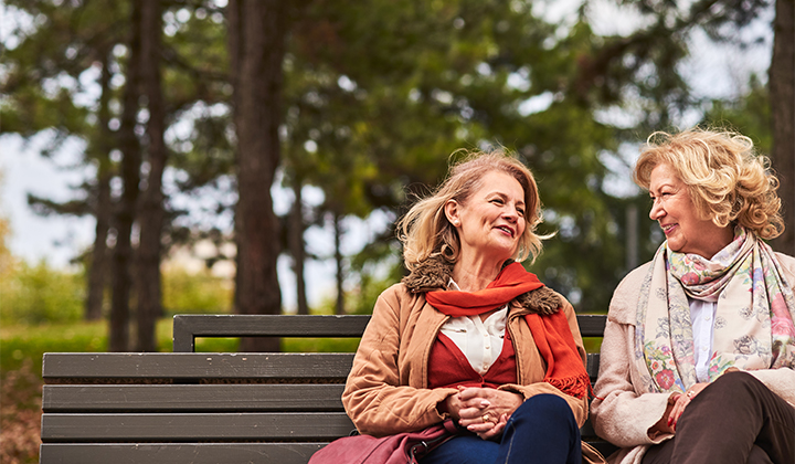 Friends talking outside on bench
