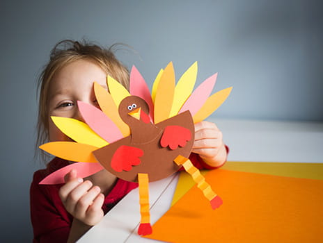 Child holding up a turkey craft