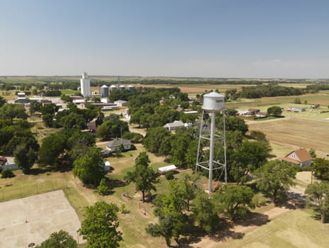 Aerial image of rural town with water tower and farmland.