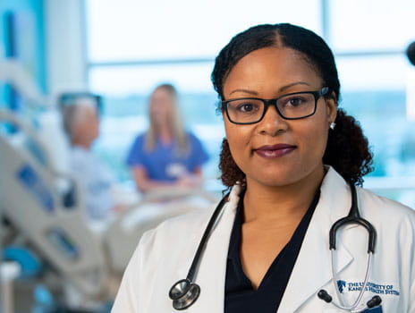 Female doctor with patient in background 